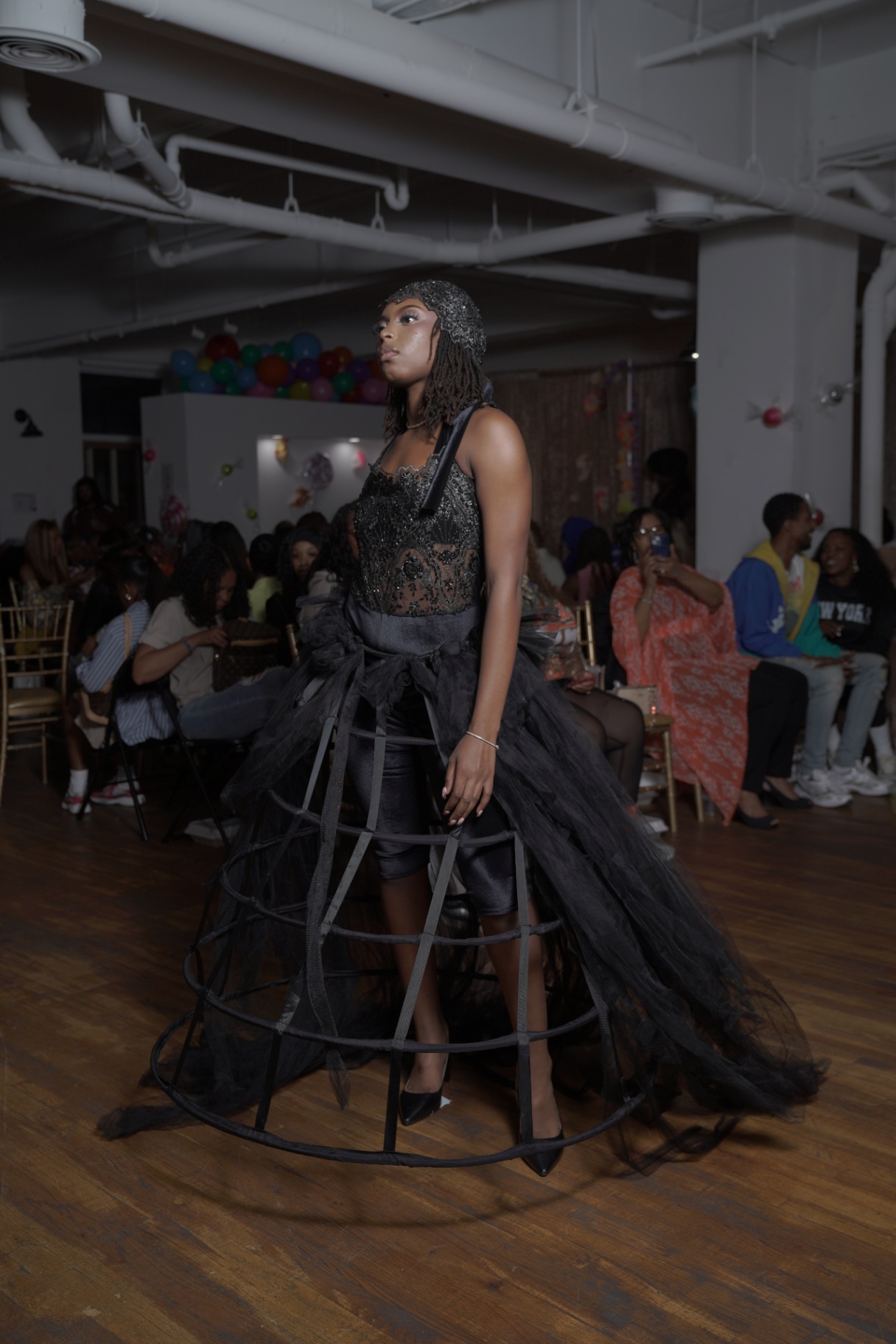 Model in a beaded corset with a black tulle cage skirt over satin shorts