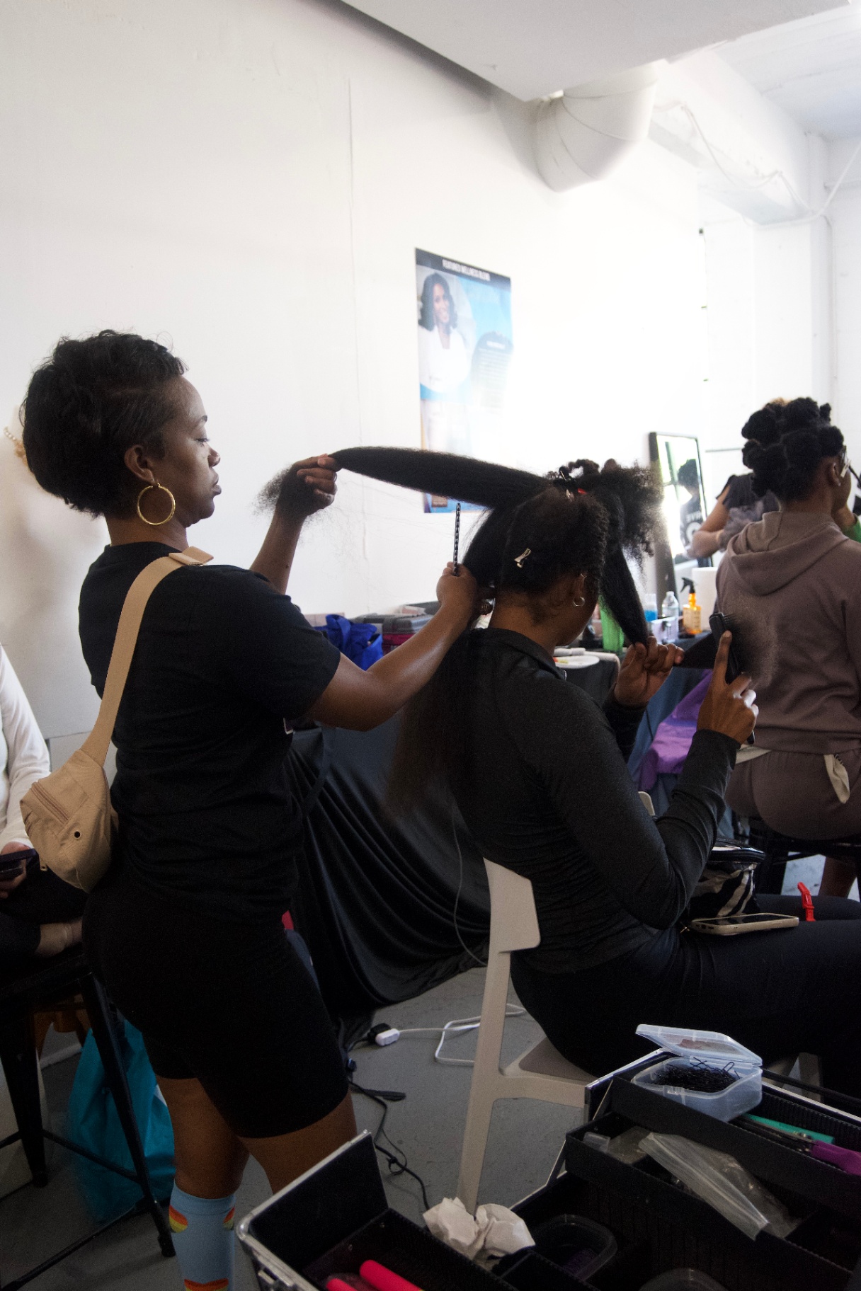 Hairstylist adding length to a model's ponytail