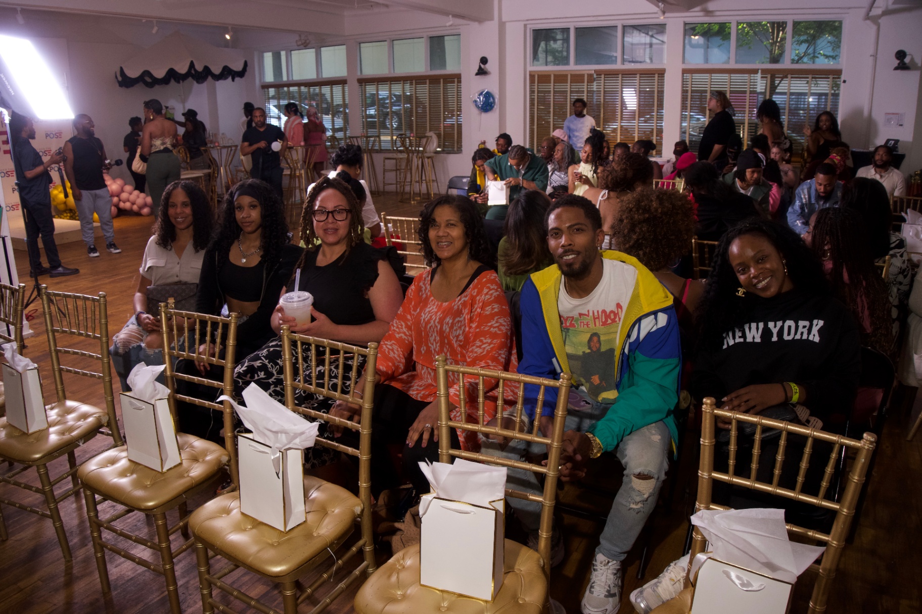 Wide shot of the packed Sugar Rush audience seated in gold chiavari chairs