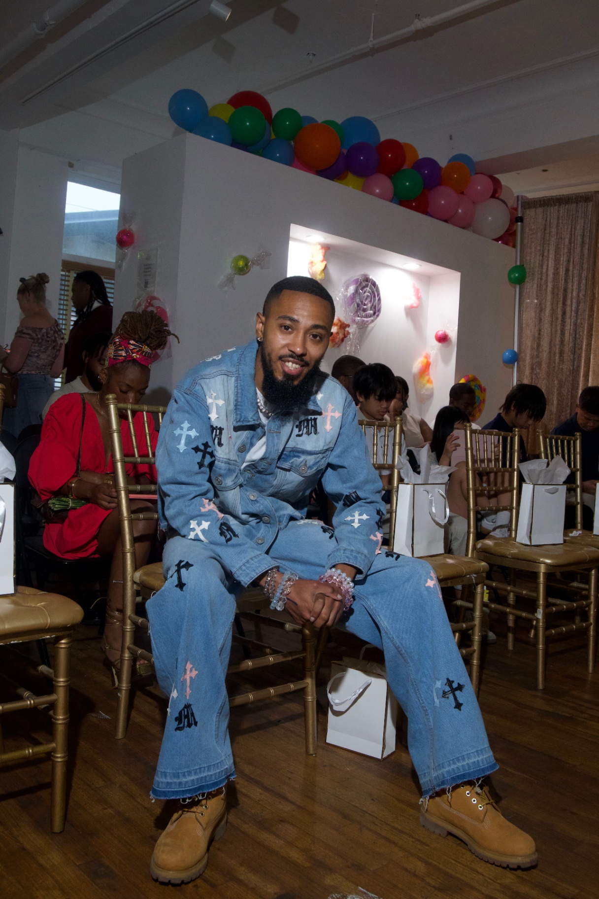 Guest in a denim cross-print set seated among the audience