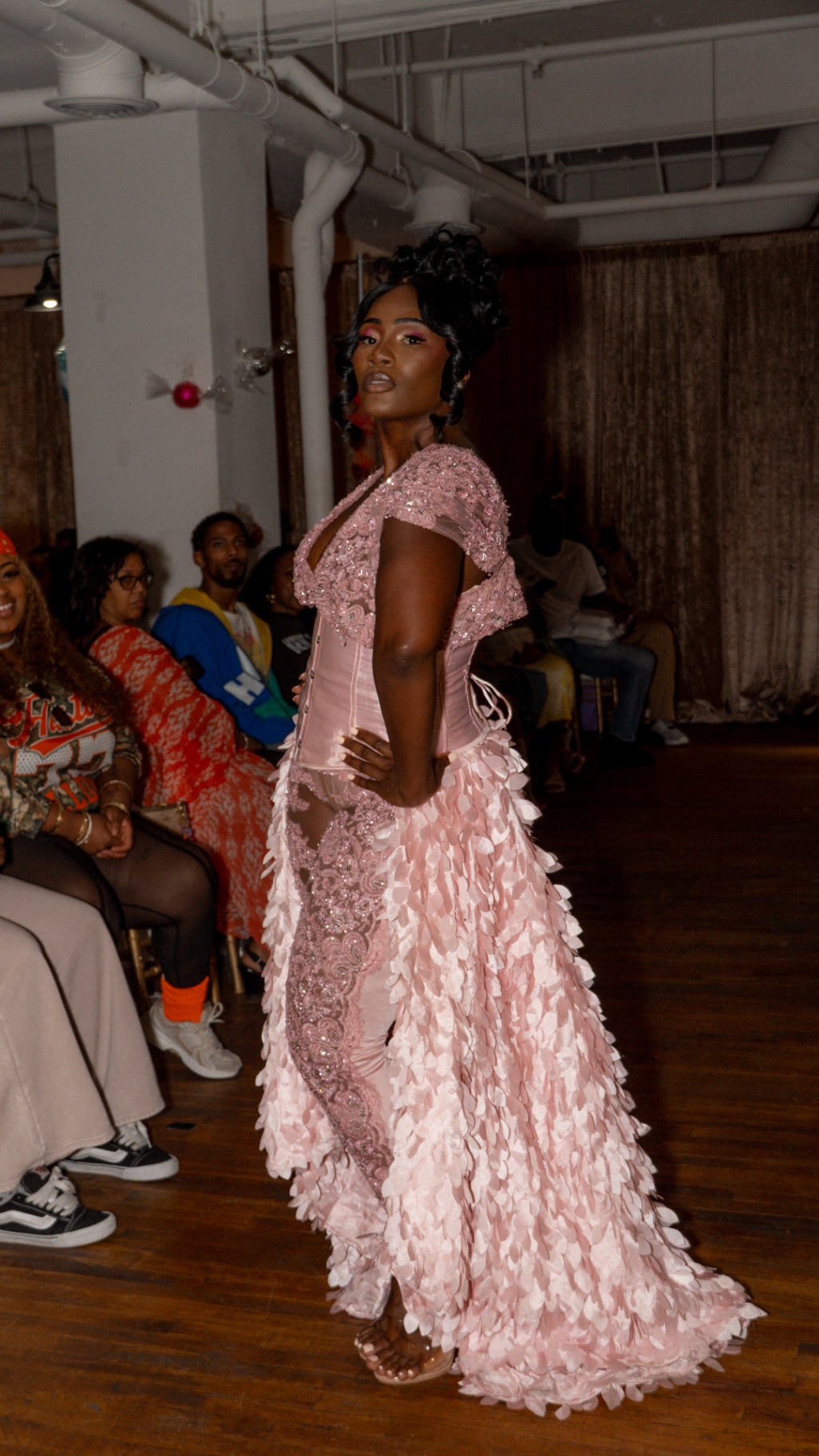 Model in a pink corset gown with a petal-textured train