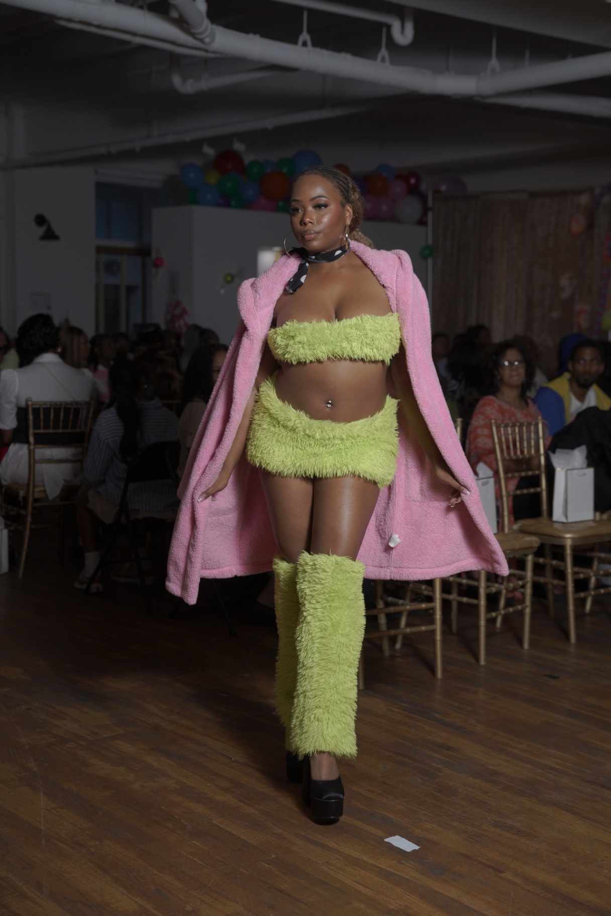 Model in a lime green fur set with a pink teddy coat on the runway