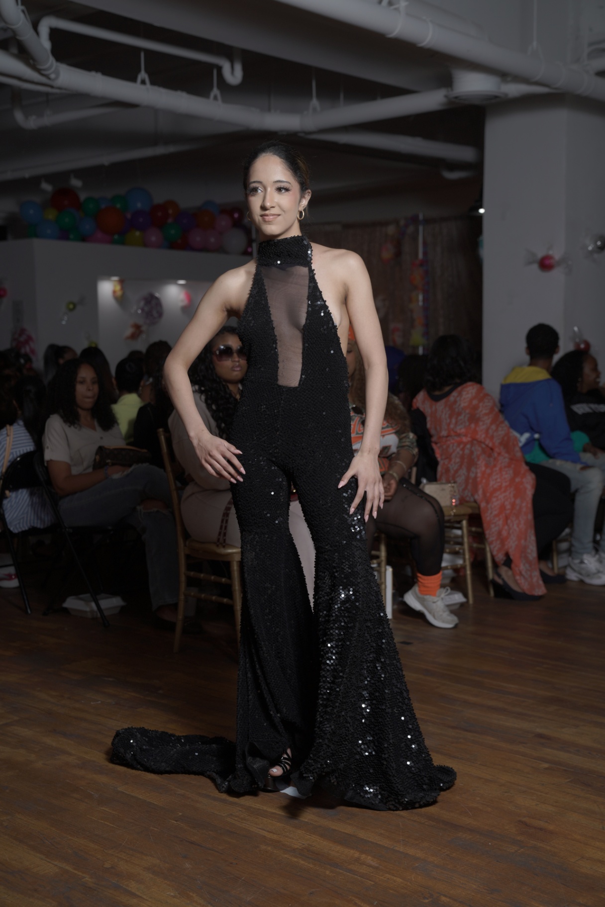 Model in a black sequin halter jumpsuit with sheer inset