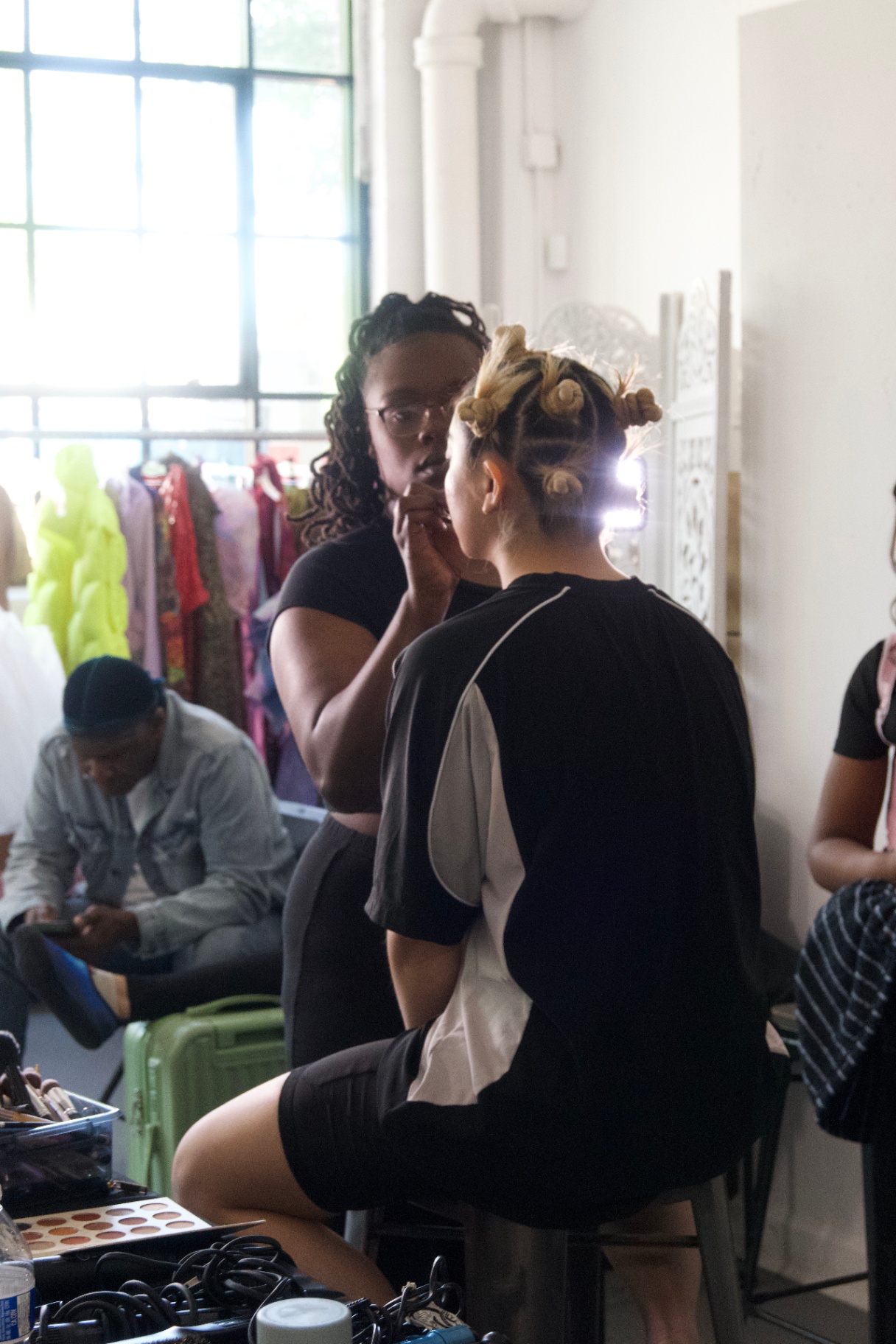 Makeup artist working on a model with pin curls