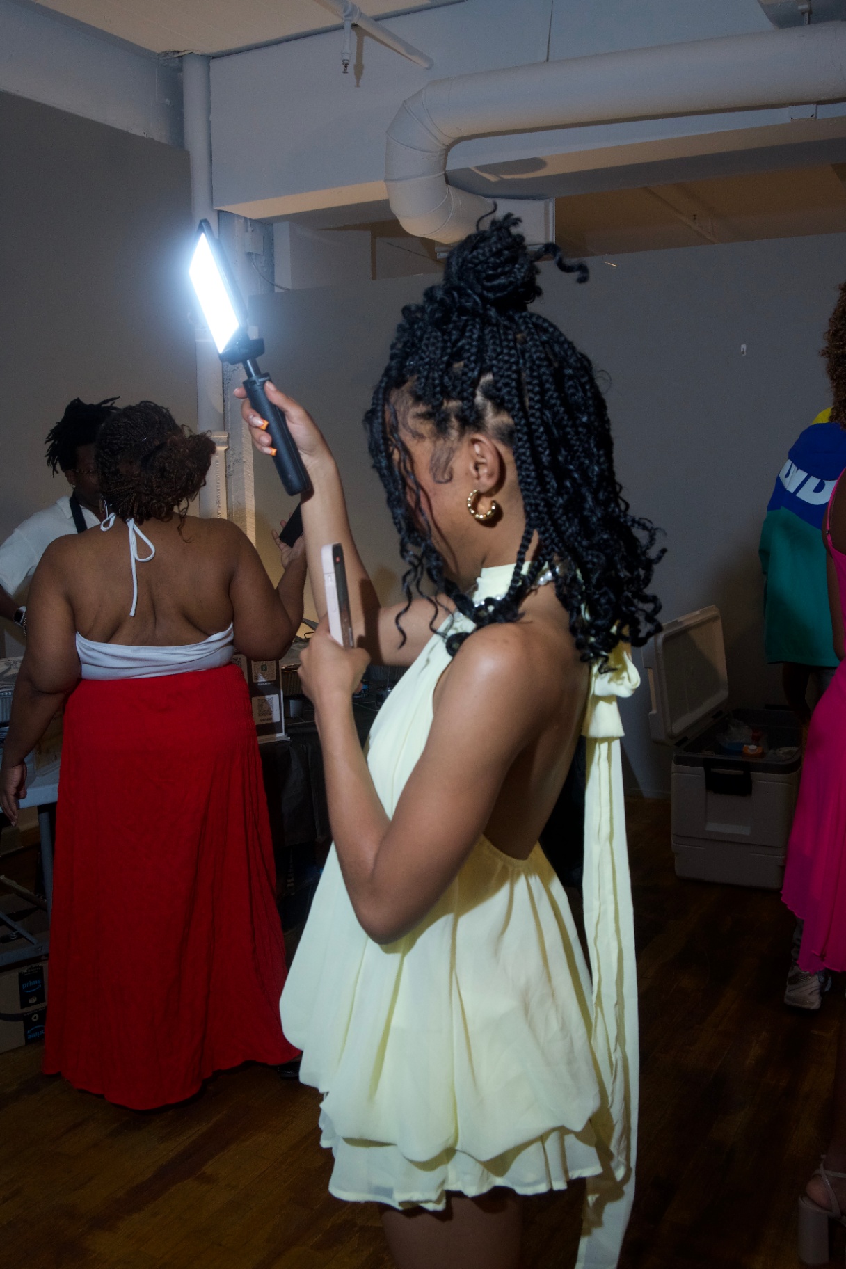 Guest in a pale yellow halter dress holding a light wand
