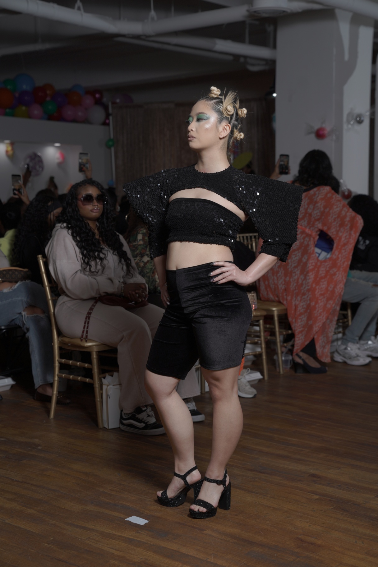 Model in a black sequin crop set with dramatic shoulders