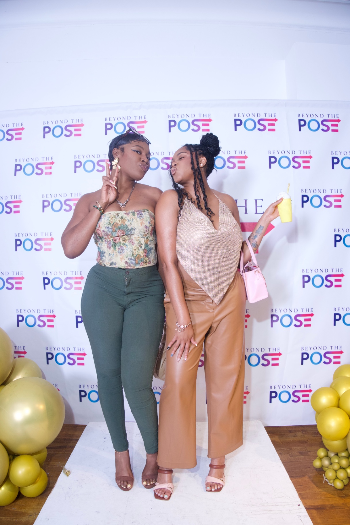 Two guests posing on the Beyond the Pose step-and-repeat